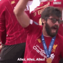 a man with a beard wearing sunglasses and a medal around his neck is holding a trophy in his hand .