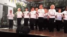 a group of women are dancing on a stage in front of a sign that says ' lee ' on it