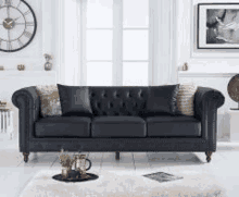 a black leather couch is sitting in a living room next to a clock .