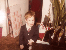 a young boy in a suit stands in front of a box that says pork chop hill