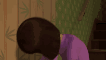 a woman in a purple shirt is bending over in front of a wall