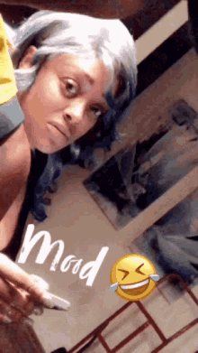 a woman with blue hair is making a funny face next to a smiley face that says " mad "