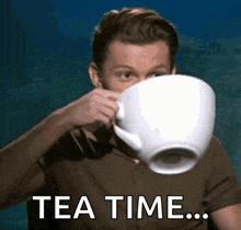 a man is drinking a large cup of tea with the words tea time written above him