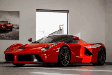 a red sports car is parked in front of a window in a showroom