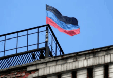 a blue red and black flag is flying from a balcony