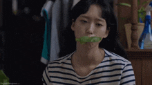 a woman with a lettuce leaf in her mouth