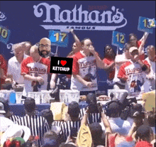 nathan 's famous hot dog eating contest with a man holding a sign that says " i love ketchup "