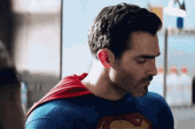 a man in a superman costume is looking down at something