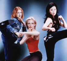 three women posing for a picture with one wearing a red top