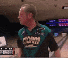 a man wearing a storm jersey is standing in a bowling alley