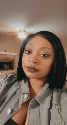 a woman taking a selfie in front of a fireplace and ceiling fan