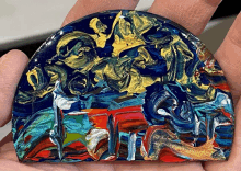 a person is holding a colorful piece of artwork