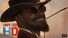 a man wearing a cowboy hat and sunglasses is smiling and smoking a cigarette