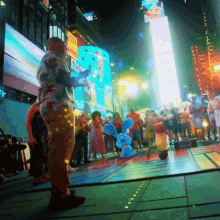 a crowd of people are gathered in front of a large sign that says ' times square ' on it