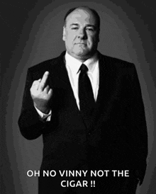 a man in a suit and tie is giving the middle finger and says oh no vinny not the cigar