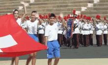 a boy holding a flag in front of a marching band with a banner that says ' switzerland ' on it