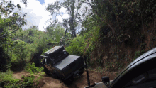 a jeep is driving down a dirt road in the woods with a license plate that says ' jc ' on it