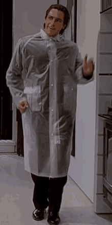 a man wearing a clear plastic raincoat is standing in a room .