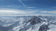 a snowy mountain range with a blue sky and clouds