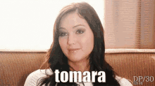 a woman sitting on a couch with the word tomara on her face