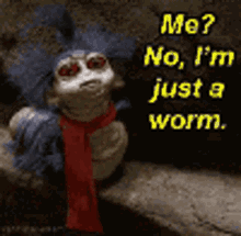 a labyrinth worm with a scarf around its neck is sitting on a rock .