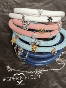 a stack of jesper nielsen bracelets with charms