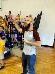 a man in a gray shirt with a name tag that says ' chris ' on it stands in front of children