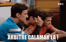 a group of men are sitting in a room and one of them is saying arbitre calamar la