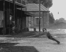 a black and white photo of a man doing push ups in front of a building that says ' abercrombie & fitch '