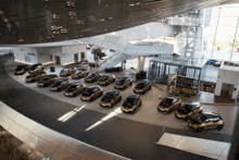 a row of cars are parked in a large building .