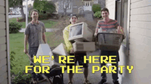 a group of young men are standing in front of a house holding a computer and a basket of groceries .