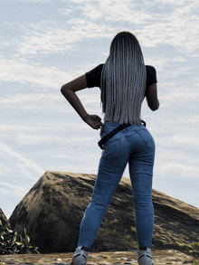 a woman with gray hair is standing on a rock