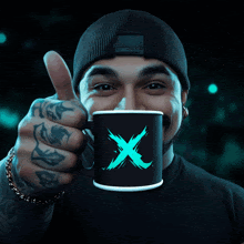 a man is holding a mug with a blue x on it and giving a thumbs up