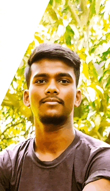 a young man with a beard wearing a black shirt looks at the camera