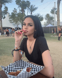 a woman sitting at a table with a container of food