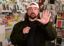 a man with long hair and a beard is standing in front of a book shelf with a book called music wizard on it