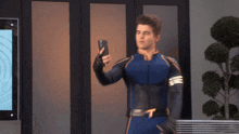 a man in a superhero suit is taking a selfie with his phone