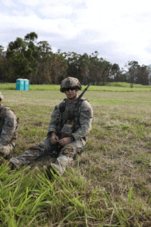 a man in a military uniform sits on the grass