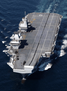 a large military ship is floating in the ocean with the letter c on the bottom