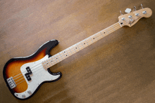 a fender bass guitar laying on a wooden floor