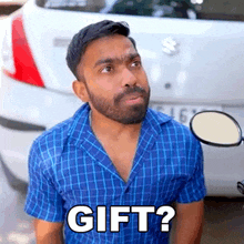 a man with a beard is standing in front of a car and asking if he has a gift ?