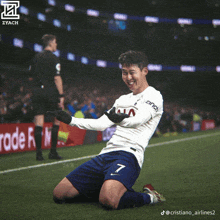 a soccer player kneeling on the field with the number 7 on his jersey