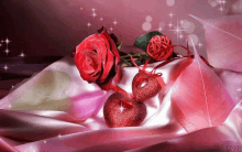 a red rose sits on a pink cloth next to two red heart shaped decorations