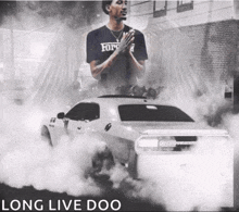 a man standing next to a car that says long live doo on the bottom