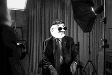 a black and white photo of a man in a suit and tie with a cartoon face on his face