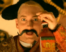 a man wearing a sombrero and a mustache holds a bottle of dirty sauce