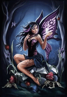 a fairy with purple wings is sitting on a rock in the woods holding a butterfly .