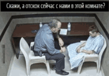 a man in a hospital gown sits next to another man in a chair