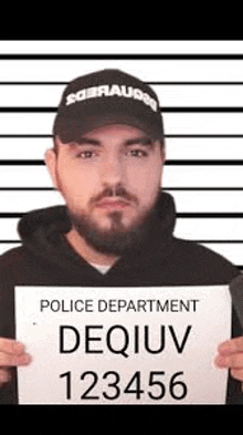 a man with a beard and a hat is holding a police department mug shot .