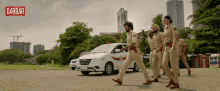 a group of police officers are walking in front of a white car with the word darbar on the bottom